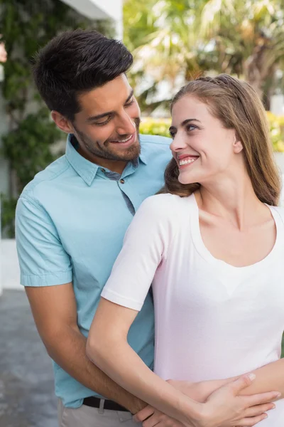 Loving man embracing woman from behind outdoors — Stock Photo, Image