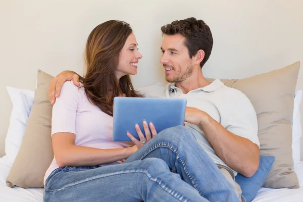 Feliz pareja relajada usando tableta digital en la sala de estar —  Fotos de Stock
