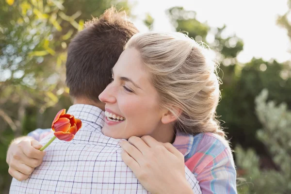 Sonriente joven pareja abrazándose en parque —  Fotos de Stock