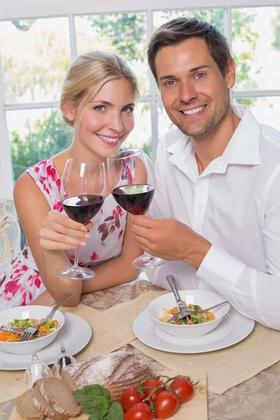 Pareja cariñosa con copas de vino sentada en la mesa —  Fotos de Stock