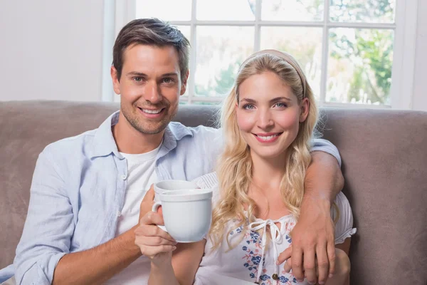 Retrato de um casal amoroso com xícaras de café na sala de estar — Fotografia de Stock