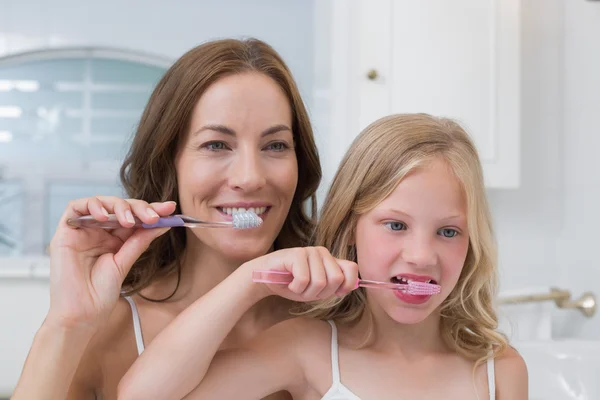 Moeder en dochter borstelen tanden in de badkamer — Stockfoto