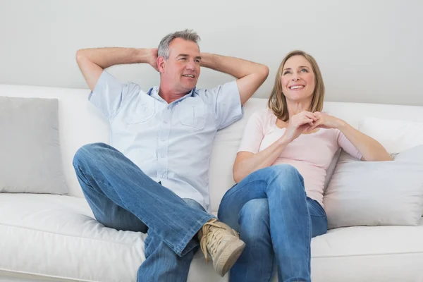 Happy relaxed couple sitting on sofa in living room — Stock Photo, Image