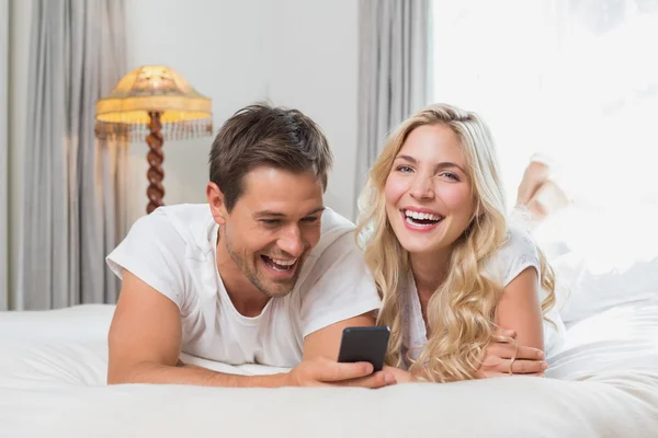 Alegre relaxado casal leitura texto mensagem no cama — Fotografia de Stock