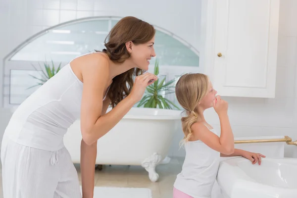 Niña cepillándose los dientes con madre — Foto de Stock