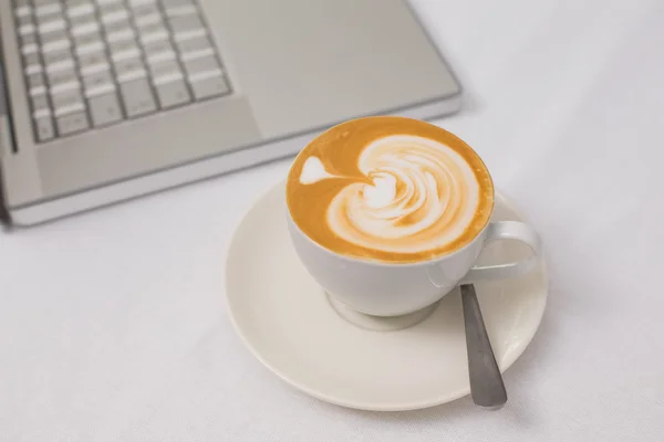 Kawa i laptopa na stole — Zdjęcie stockowe