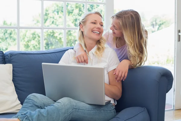 Mother and daughter with laptop looking at each other — Stock Photo, Image