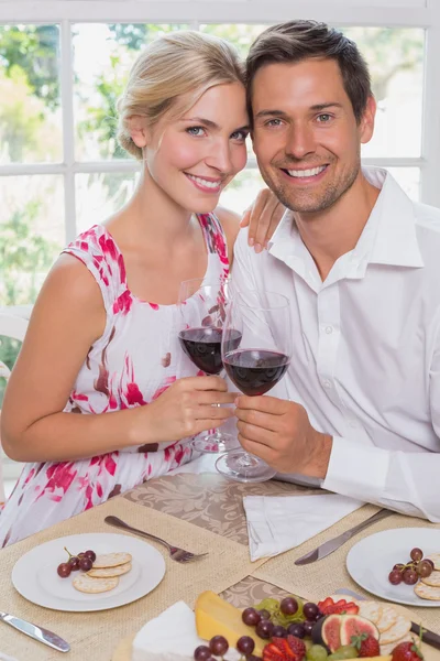 Amour jeune couple avec des verres à vin à la table à manger — Photo
