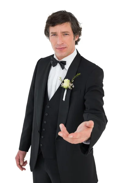 Confident groom in tuxedo offering hand — Stock Photo, Image