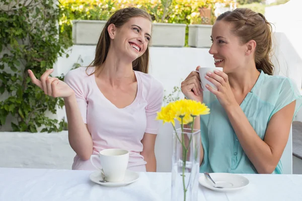 Amigos felizes do sexo feminino tomando café na loja — Fotografia de Stock
