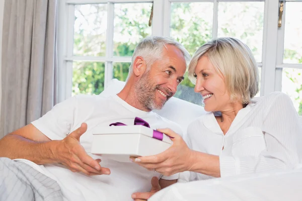 Vrouw het geven van volwassen man een doos van de gift — Stockfoto