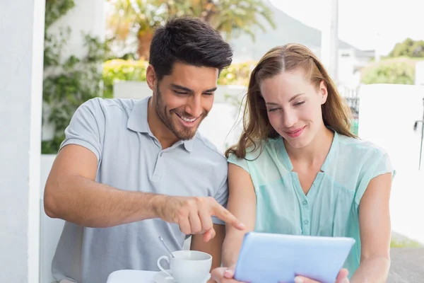 Casal com xícara de café usando tablet digital no café — Fotografia de Stock