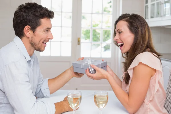 ผู้ชายที่ให้กล่องของขวัญกับผู้หญิงที่มีความสุขที่บ้าน — ภาพถ่ายสต็อก