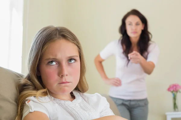 Angry girl with mother scolding her in background — Stock Photo, Image