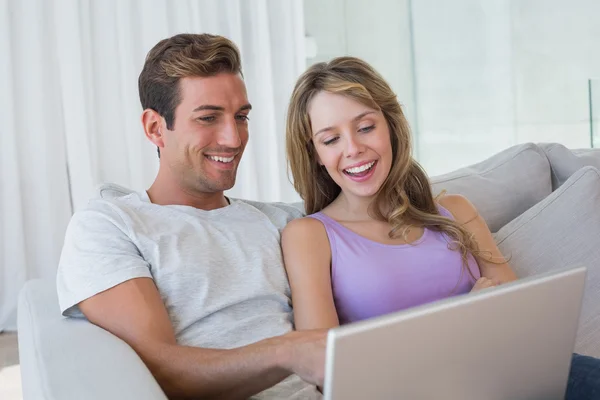 Relaxed couple using laptop on couch — Stock Photo, Image