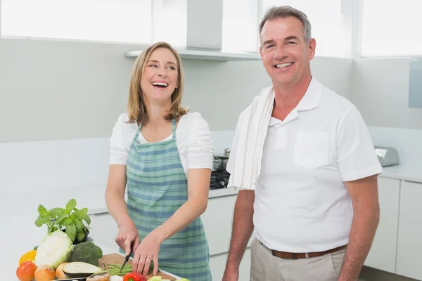 Happy couple preparing food together in kitchen — Stock Photo, Image