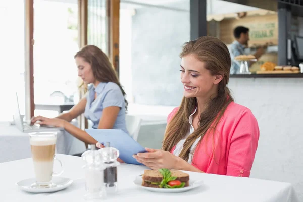 Mujer usando tableta digital en la cafetería —  Fotos de Stock