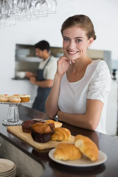 Confident cafe owner with sweet food at counter — Stock Photo, Image