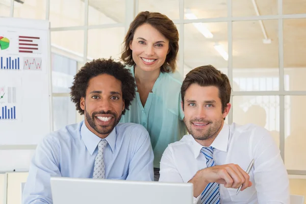 Glimlachende mensen uit het bedrijfsleven met behulp van laptop op kantoor — Stockfoto