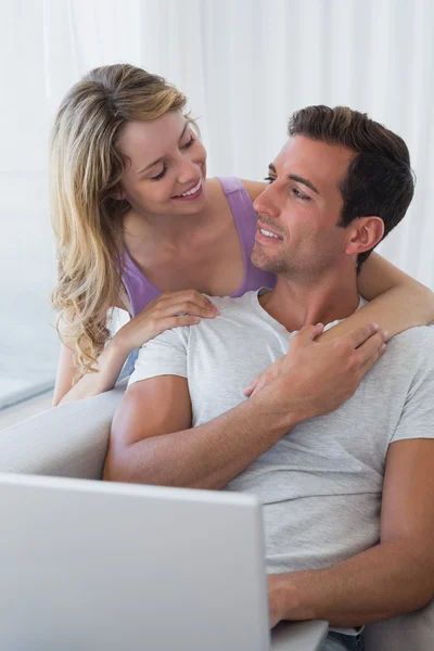 Miłej pary za pomocą laptopa na kanapie — Zdjęcie stockowe
