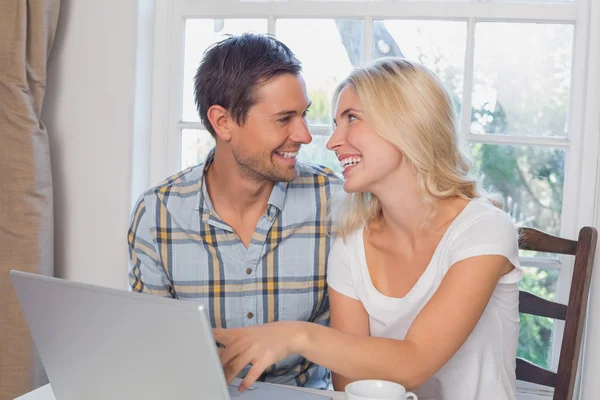 Allegro giovane coppia utilizzando il computer portatile a casa — Foto Stock