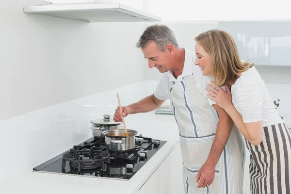 Happy couple preparing food in the kitchen — Stock Photo, Image