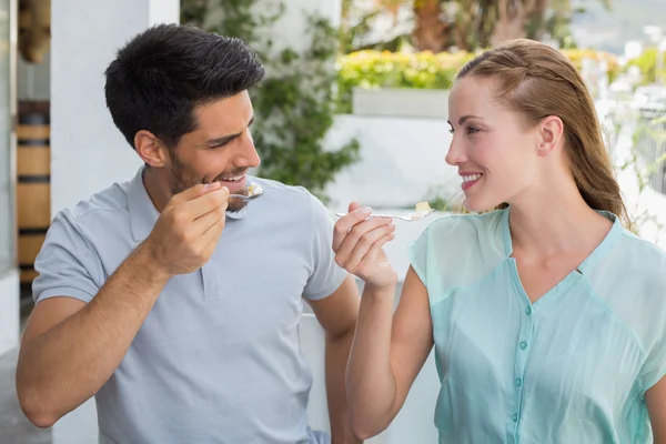 Fröhliches junges Paar isst im Café — Stockfoto