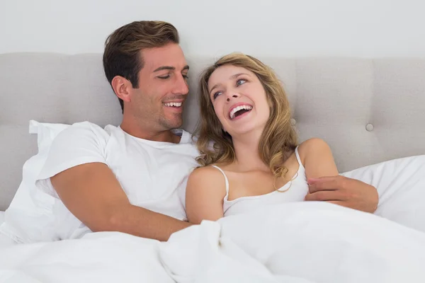 Vrolijke ontspannen paar zitten in bed — Stockfoto