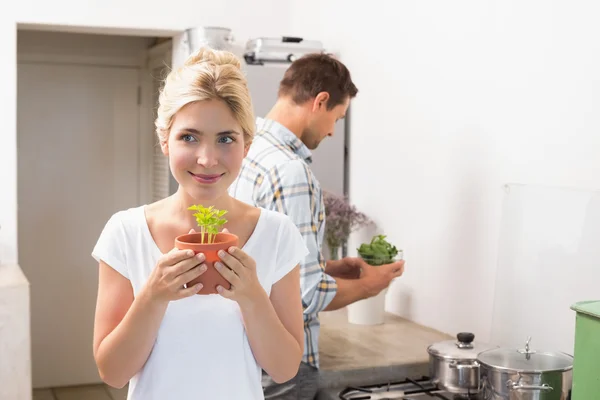 Couple with young potted plants in the kitchen — Stock Photo, Image