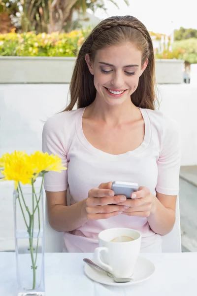 Žena s kávy šálek textových zpráv v kavárně — Stock fotografie