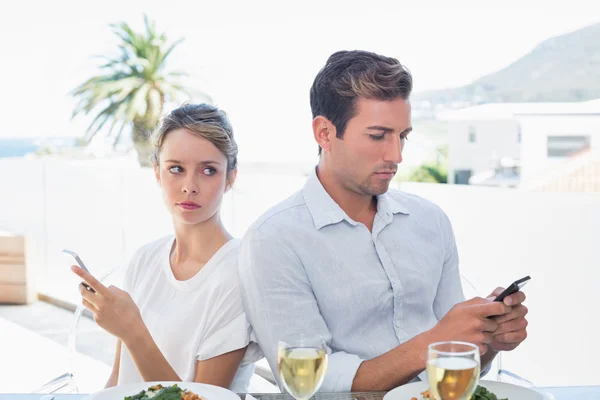 Paar van het tekstoverseinen aan voedsel tafel — Stockfoto