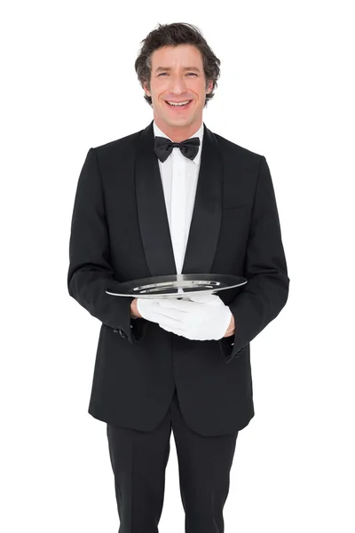 Happy waiter holding empty tray over white background — Stock Photo, Image