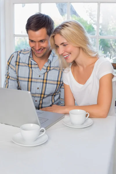 Couple souriant utilisant un ordinateur portable dans la cuisine — Photo