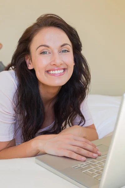 Ontspannen vrouw met laptop in bed thuis — Stockfoto