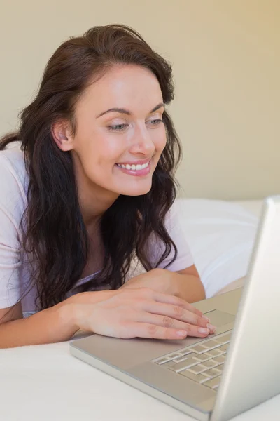 Woman using laptop in bed — Stock Photo, Image