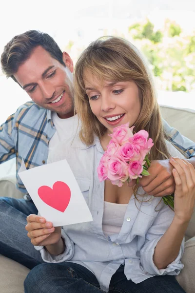 Casal amoroso com flores e cartão de saudação — Fotografia de Stock