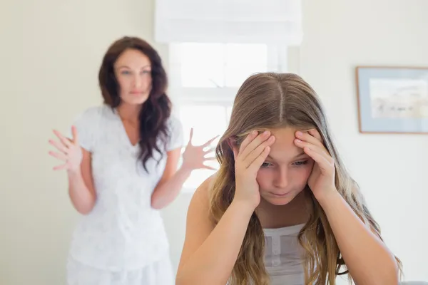 Frustrated girl in bed while mother scolding her — Stock Photo, Image