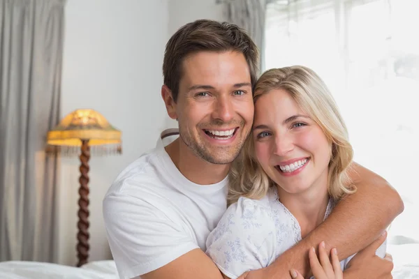Loving man embracing woman from behind at home — Stock Photo, Image