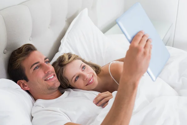 Relaxed couple using digital tablet on couch — Stock Photo, Image