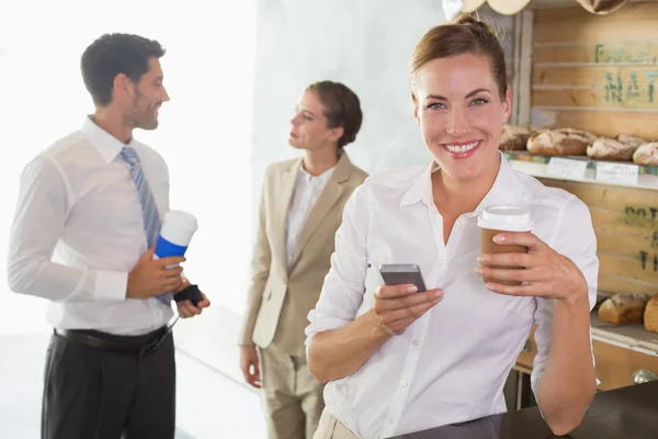 Businesswoman using mobile phone in office cafeteria — Stock Photo, Image