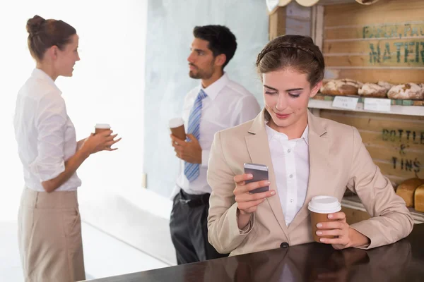 Businesswoman using mobile phone in office cafeteria — Stock Photo, Image