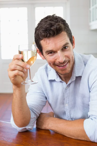 Usmívající se mladý muž, který držel sklenici na víno — Stock fotografie