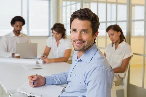 Homme d'affaires souriant avec ses collègues lors d'une réunion au bureau — Photo