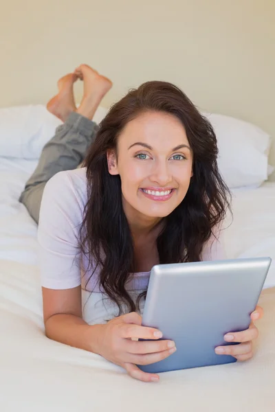 Frau hält digitales Tablet im Bett — Stockfoto