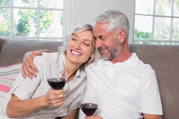 Loving mature couple with wine glasses in living room — Stock Photo, Image