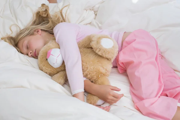 Chica durmiendo tranquilamente con peluche en la cama —  Fotos de Stock