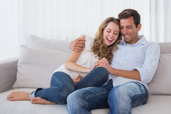 Retrato de um casal amoroso sentado no sofá — Fotografia de Stock