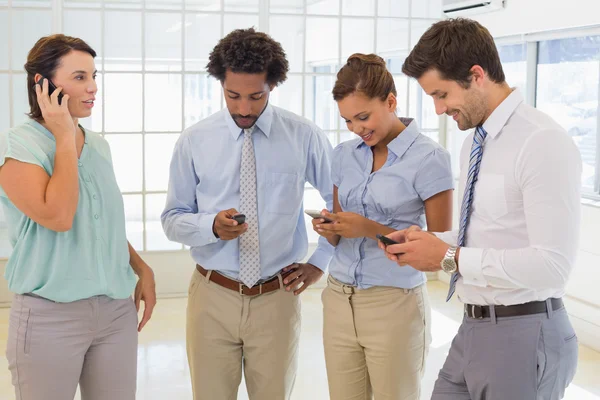 Compañeros de negocios mensajería de texto en la oficina —  Fotos de Stock