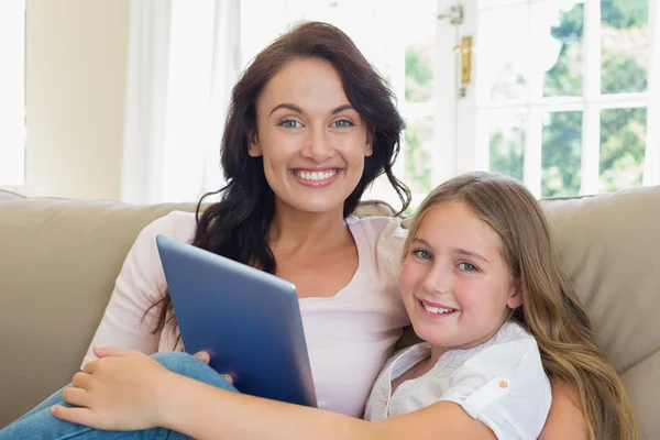 母亲和女儿坐在沙发上的数字平板电脑 — 图库照片