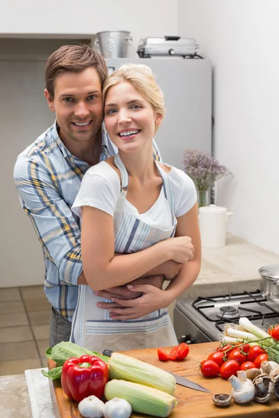 Retrato de una pareja abrazando mientras prepara comida en la cocina — Foto de Stock